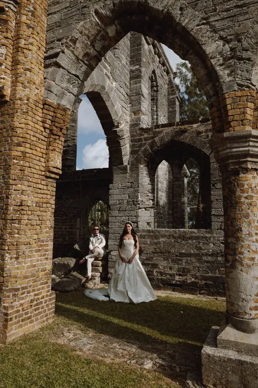 Gothic arch of a roofless church with two small figures beneath it