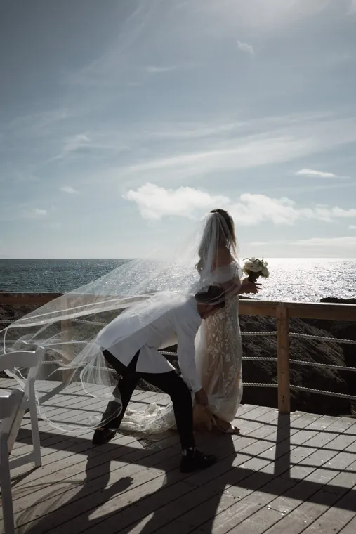 A veil caught in the wind above the water